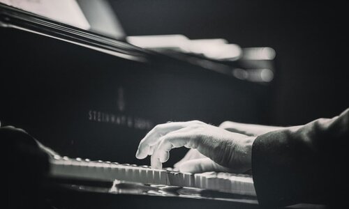 Man playing a Steinway piano in black and white